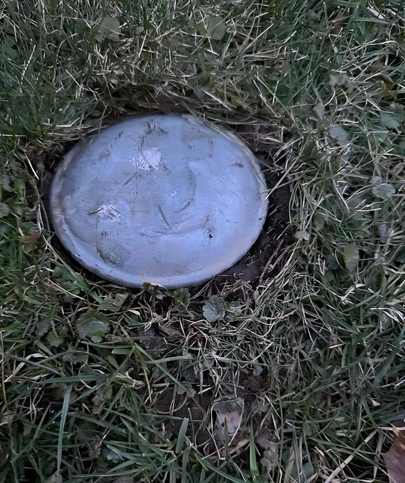 I recently bought a new house and this is in my backyard. Looks like a cap of some sort, about 6 inches in diameter. Feels like metal and is embedded into the ground.