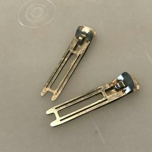 Found a whole box of these odd little metal clips while cleaning out my grandmother’s dresser.  Any guesses?